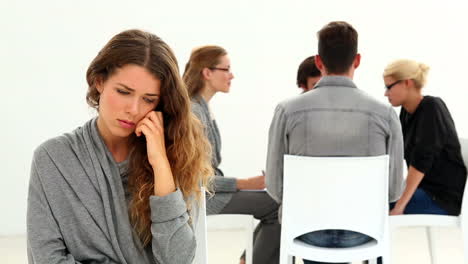 rehab group sitting in a circle with one woman excluded