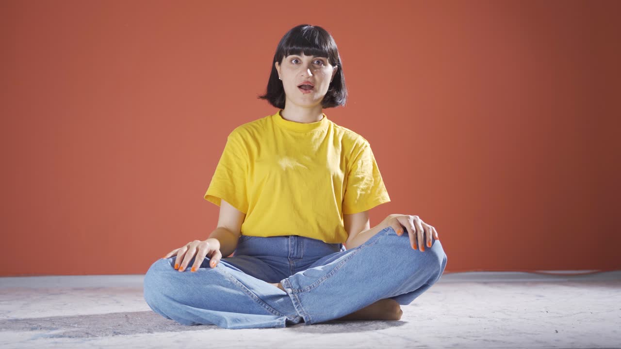 여자는 혼란스럽게 카메라를 쳐다보고 있습니다.