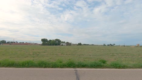 a view from my truck as i drive down this road with farms and old houses