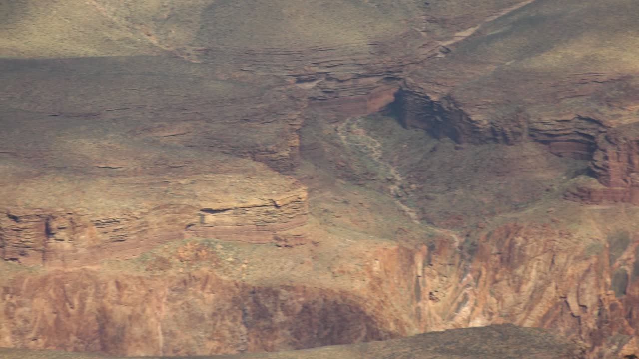 una panorámica lenta del borde sur del gran cañón, ampliada en el detalle de la roca