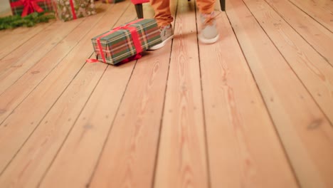 young boy is smashing christmas present to the ground and kicking it away