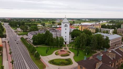 jelgava's white tower and national monument appear beneath cloudy summer sky