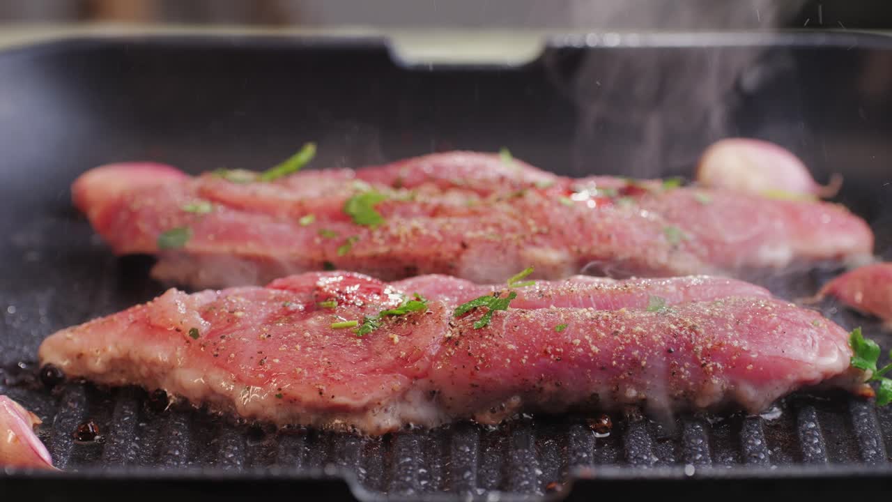 Cooking raw turkey meat in spices with garlic and greens on grill close-up. Fry chicken or turkey slice on frying pan Grilled chicken, duck, turkey kebab with vegetables.