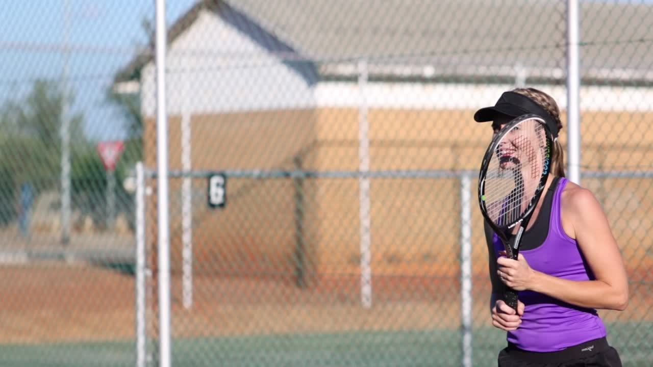 테니스 코트에서 테니스를 치는 여성 테니스 선수의 영상을 클로즈업하세요