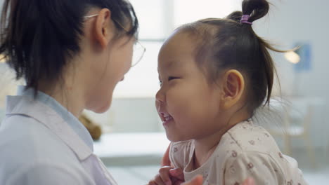 asian toddler girl playing with pediatrician