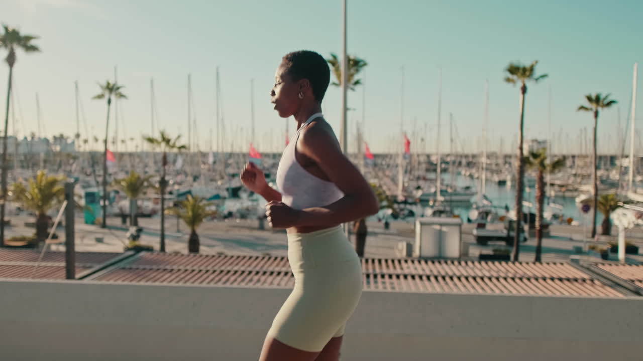 Giovane donna afroamericana che fa jogging lungo il lungomare