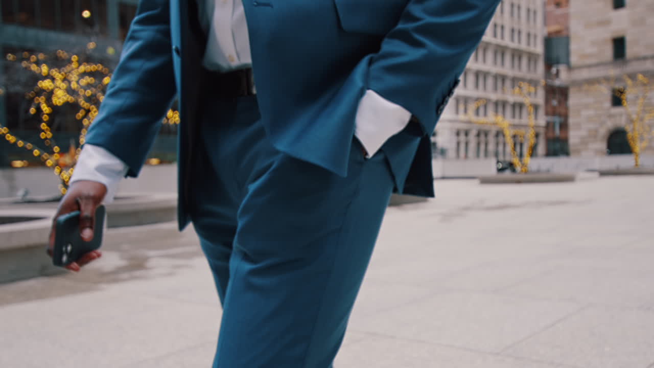 New York, USA, 28 maggio 2025: Primo piano di un completo da lavoro blu con la mano in tasca. Scatto dettagliato del tessuto e della sartoria di un abito professionale su un uomo che cammina in ambiente urbano.