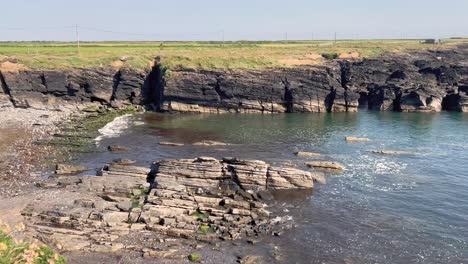 Eine-4K-Aufnahme-Des-Hook-Head-Leuchtturms,-Der-Auf-Einem-Felsvorsprung-An-Der-Küste-Von-Wexford-In-Irland-Steht