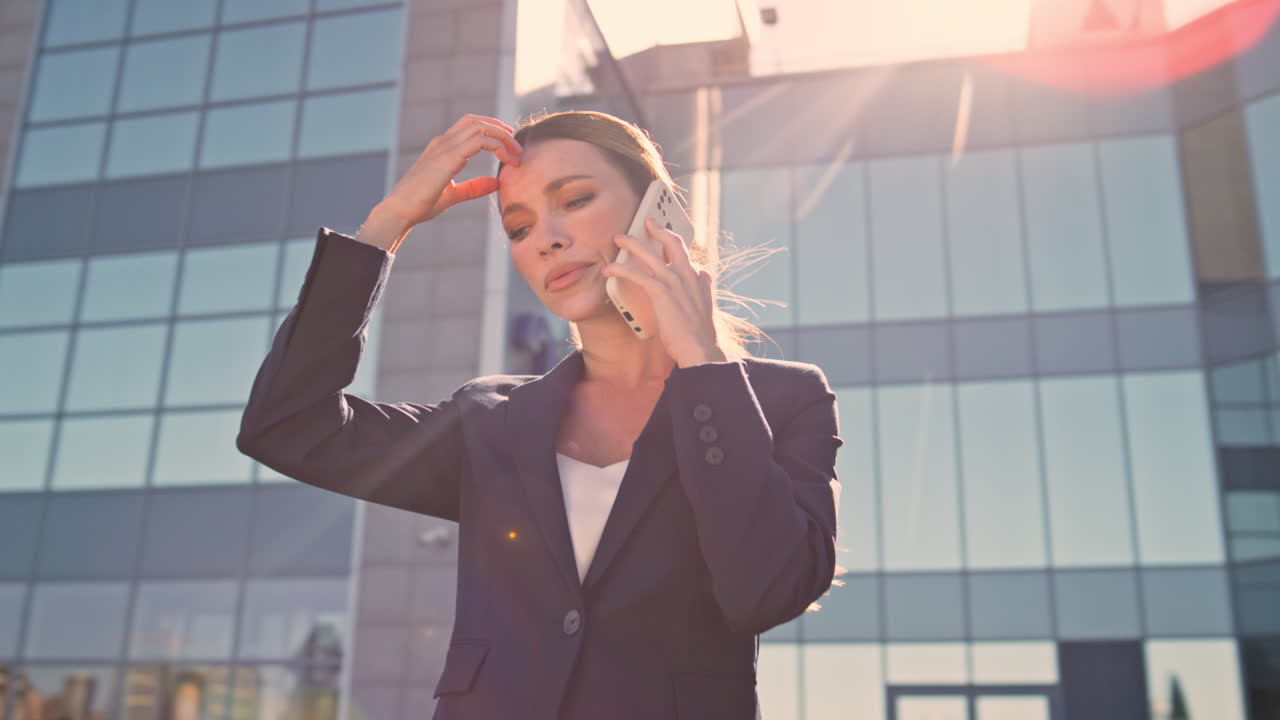 empresario molesto hablando con su teléfono inteligente en la calle a la luz del sol de la noche de cerca.