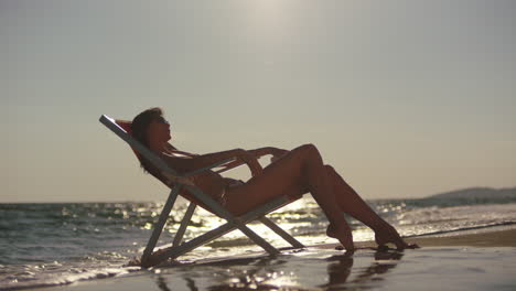 woman relaxing on beach chair at sunset