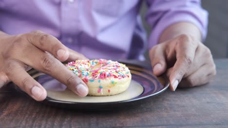 person eating a colorful sprinkled donut