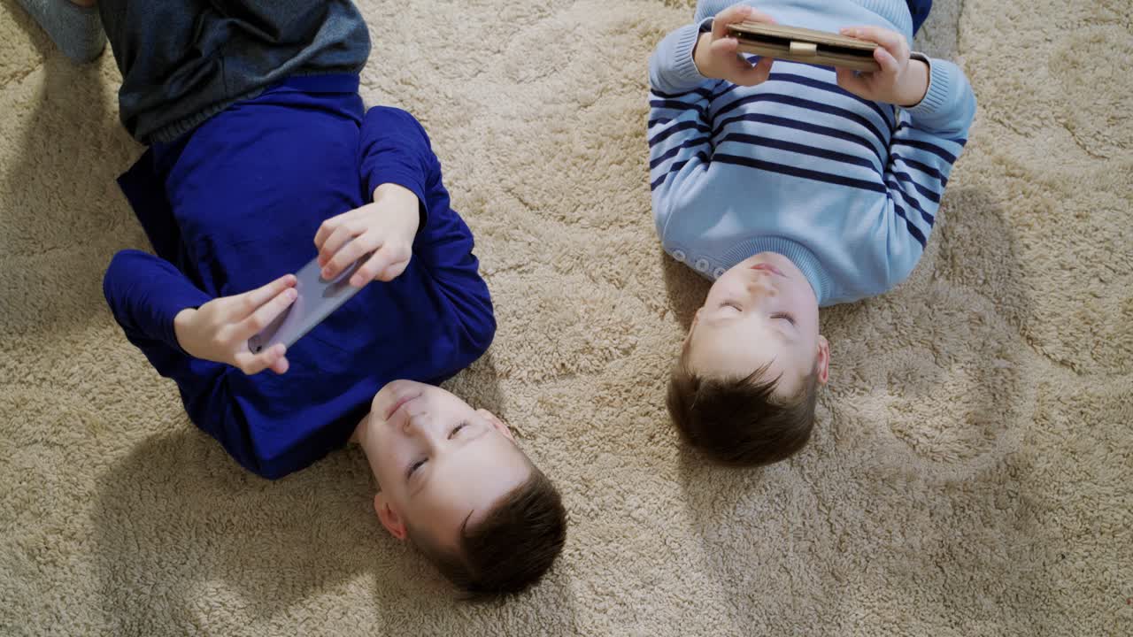 Little boys playing game on mobile together. Child playing video game at home