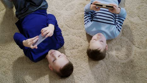 little boys playing game on mobile together. child playing video game at home