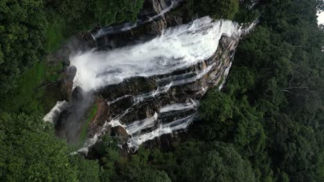 empuje aéreo lento hacia una cascada masiva en la jungla - dron vertical