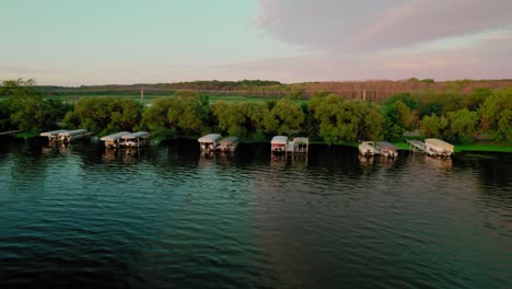 tranquil lakeside boathouses at sunset. scenic water reflections at green lake inlet boat launch site, wisconsin, usa