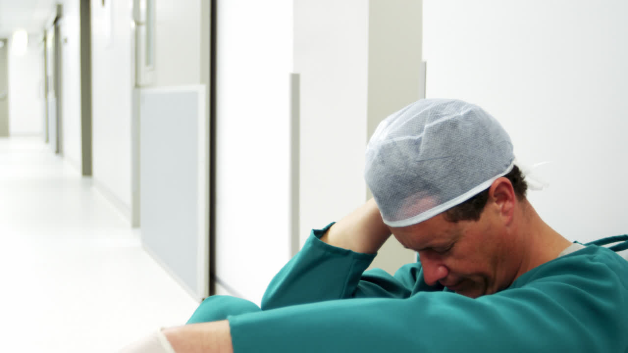 cirujano triste sentado en el suelo