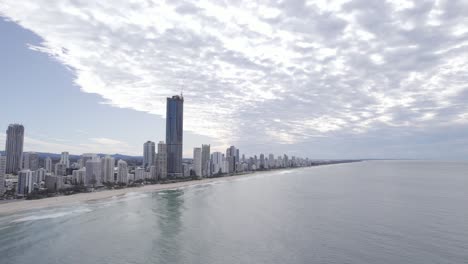 Vista-De-Edificios-De-Gran-Altura-Junto-Al-Mar-Del-Paraíso-De-Los-Surfistas-En-Gold-Coast,-Queensland-Con-Un-Avión-De-Acrobacias-Volando-Repentinamente-Y-Exhibiendo