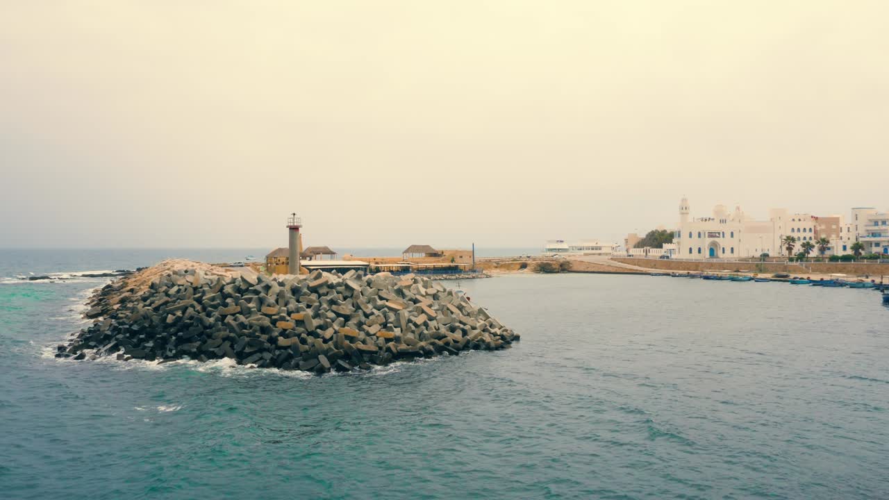 pequeño faro en una isla hecha de piedras cerca de la costa