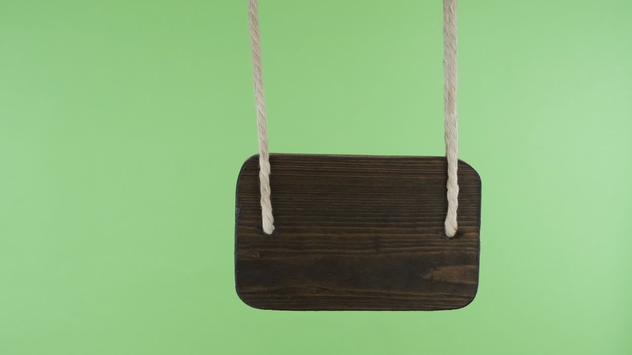 Puntatore in legno che oscilla al vento. Isolato su schermo verde.