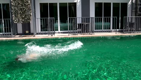 a woman comes out of hotel rooms and dives into the pool