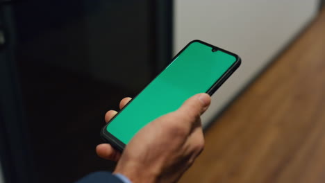 Manager-hands-holding-chroma-key-phone-closeup.-Businessman-walk-office-corridor