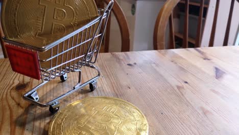 golden bitcoin crypto currency coins in tiny shopping trolley on kitchen table concept looking down orbit left