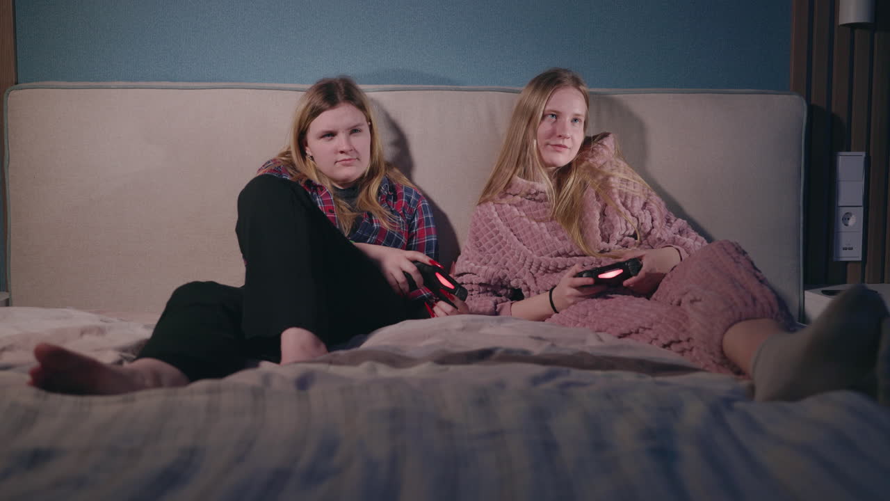 Sisters Playing Video Games in Bed
