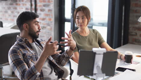 Young-Asian-man-and-Asian-woman-are-engaged-in-a-business-discussion-at-an-office