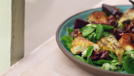 baked goats cheese and pear salad by a window, close up pan