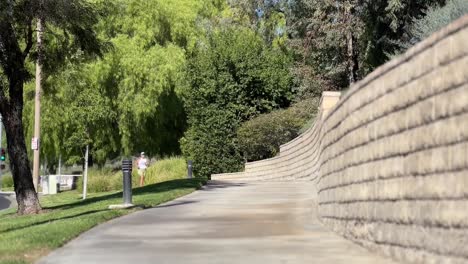 female runner seen jogging in distance on pavement in santa clara