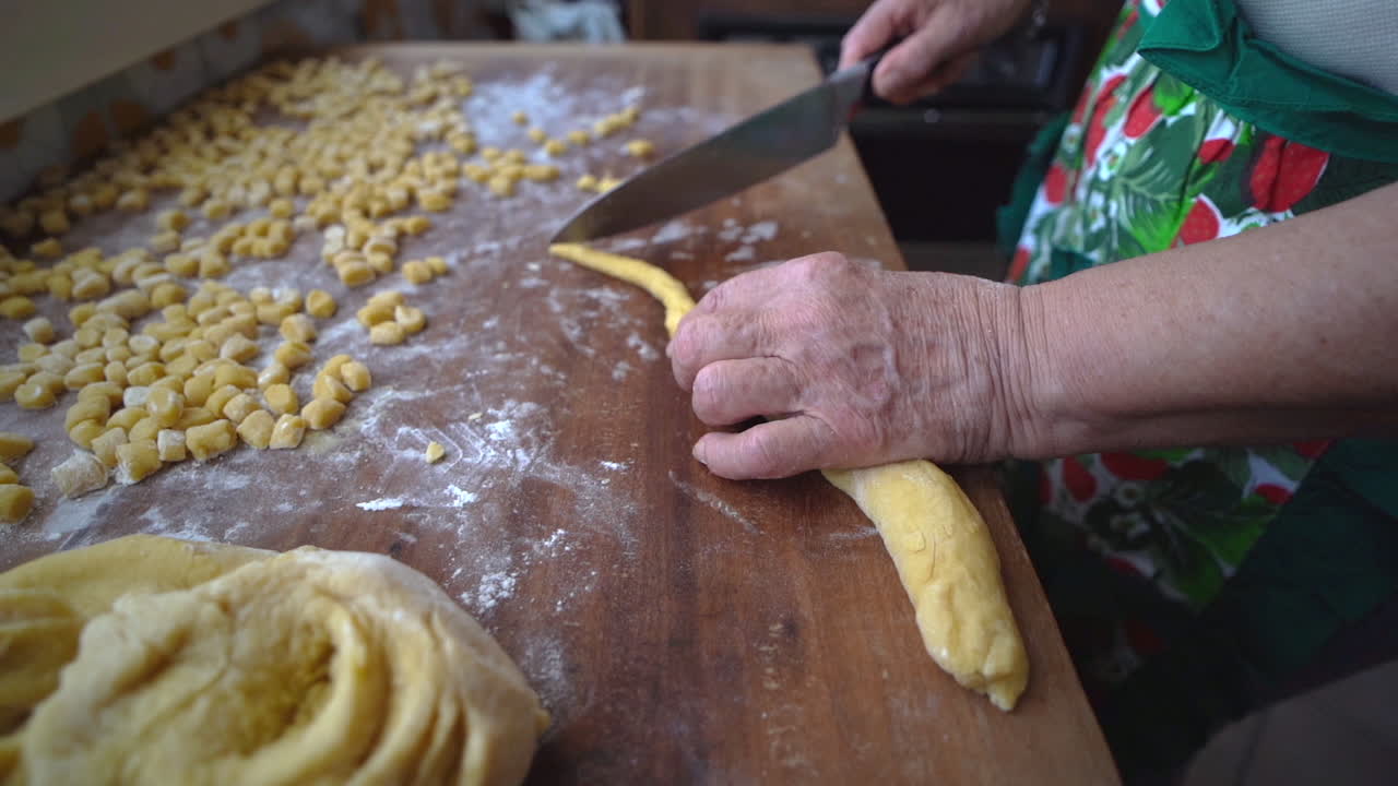 preparación artesanal de struffoli con mano de mujer cortando masa