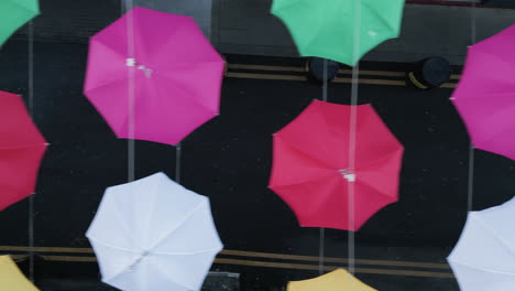 cloudy sky and a lot of multi colored umbrellas on top of street in dublin, ireland