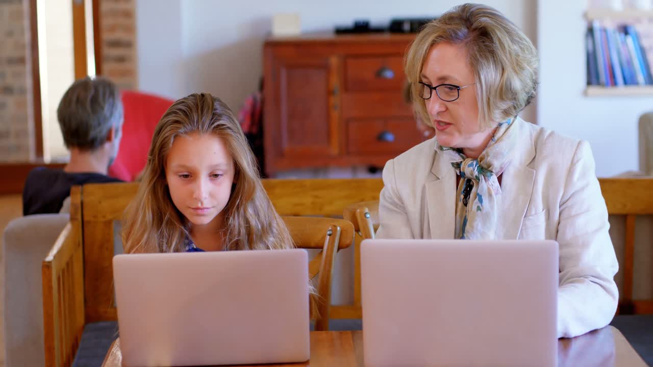 Mother and daughter interacting with each other while using laptop 4k