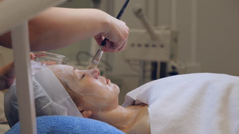 relaxed woman receives facial treatment in a spa in calm relaxing atmosphere