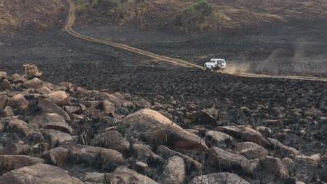 at a distance, lone truck driving on dirt road