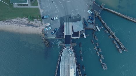 Luftdrohnenaufnahme-Von-Oben-Nach-Unten,-Wie-Die-Fähre-Vor-Sonnenaufgang-Auf-Shelter-Island-North-Fork-Long-Island-New-York-Entladen-Wird