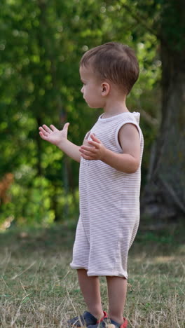 small boy in park walking. fun lifestyle child playing. vertical video