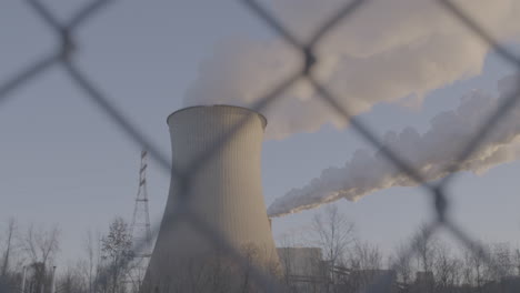 smoke stack from behind a fence
