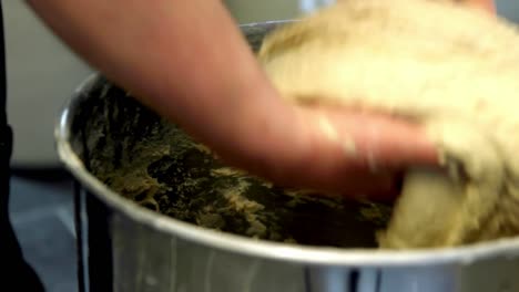 dough taken out of mixer by baker, close