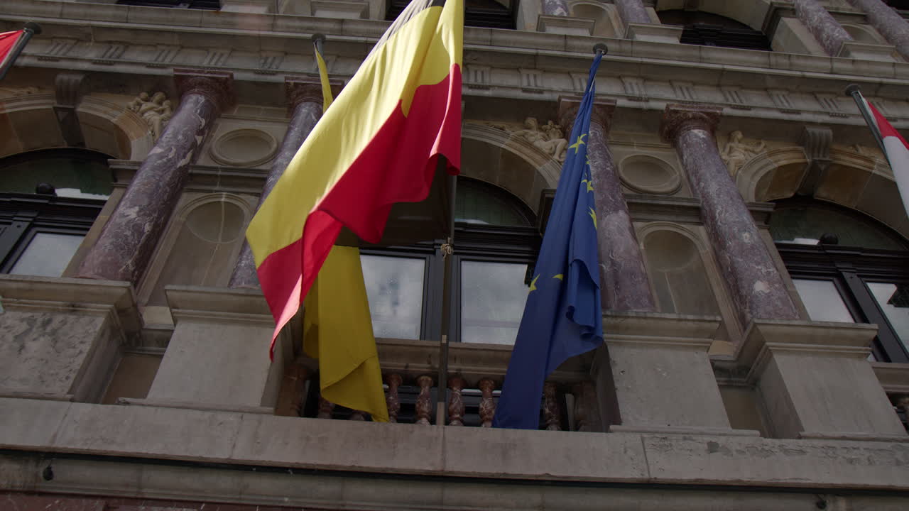 Le bandiere delle Fiandre, del Belgio e dell'Unione Europea erano esposte sulla facciata dell'edificio ad Anversa, Belgio - Scatto dal basso