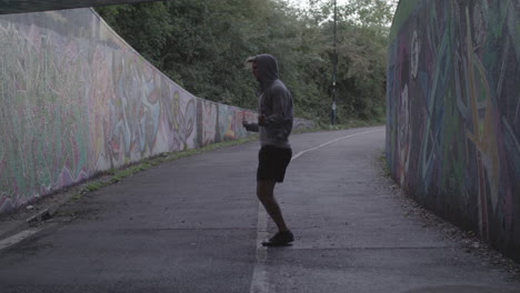 wide shot of athletic man jumping rope in an underpass in slow motion - ungraded