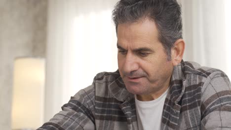 Close-up-of-lonely,-thoughtful-and-unhappy-man-playing-chess-alone.