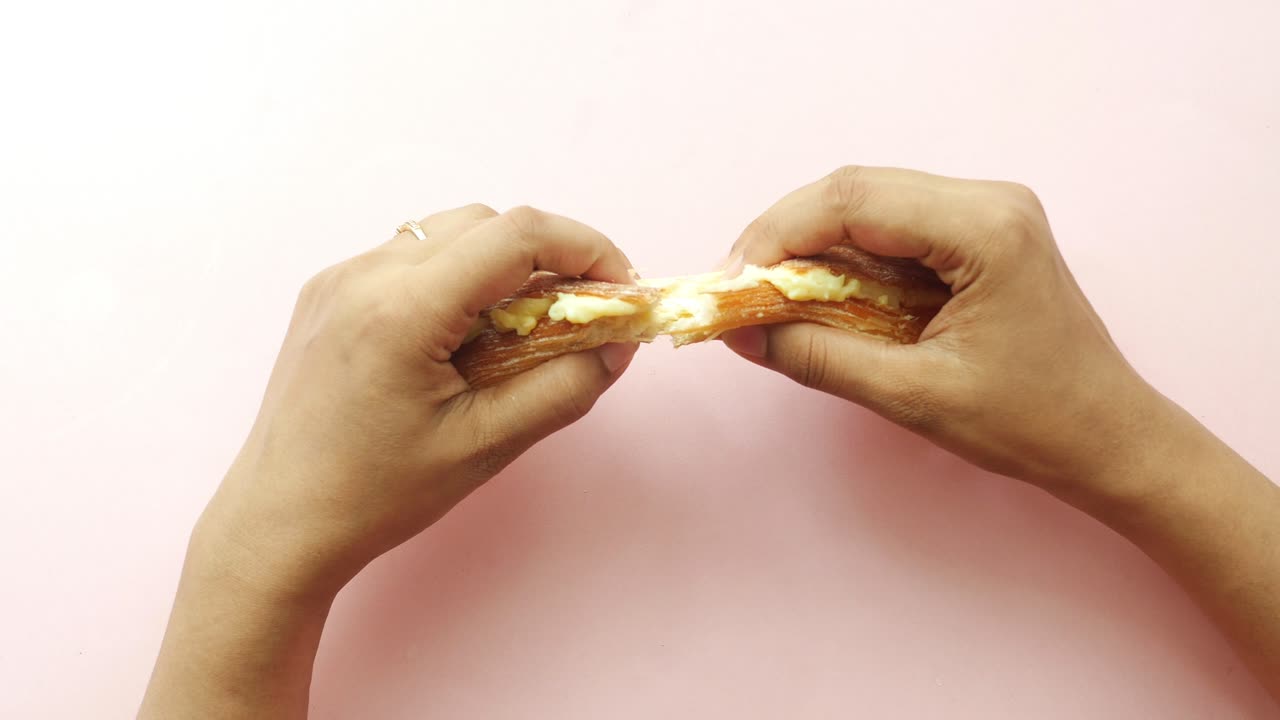 manos rasgando un pastel lleno de crema