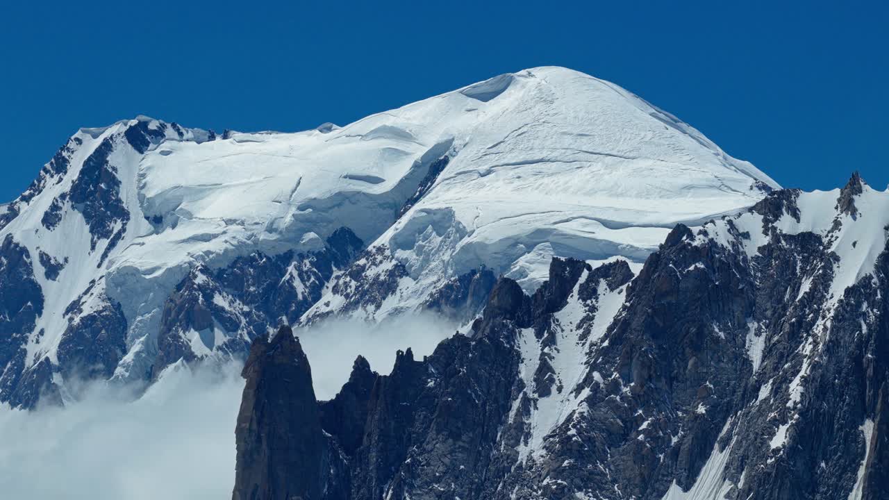 Una maestosa panoramica con drone rivela le cime innevate e gli antichi ghiacciai delle Alpi francesi vicino a Chamonix. Questo paesaggio montano cinematografico cattura la bellezza d'alta quota della catena.