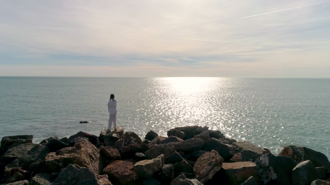 mature dancing listening to music by the sea and drone orbiting