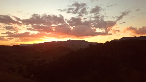 Stunning-aerial-shot-of-hills-in-sunset,-colorful-summer-sky