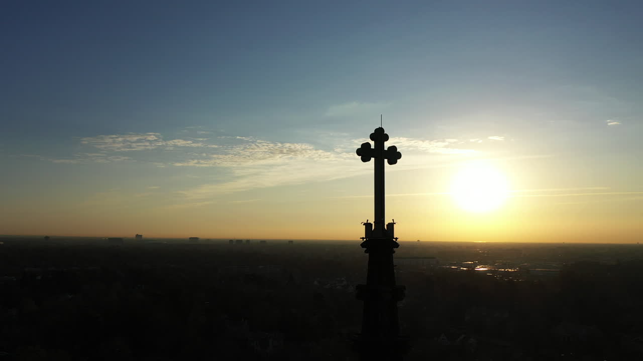 일출 동안 십자가가 있는 대성당의 첨탑의 공중 샷