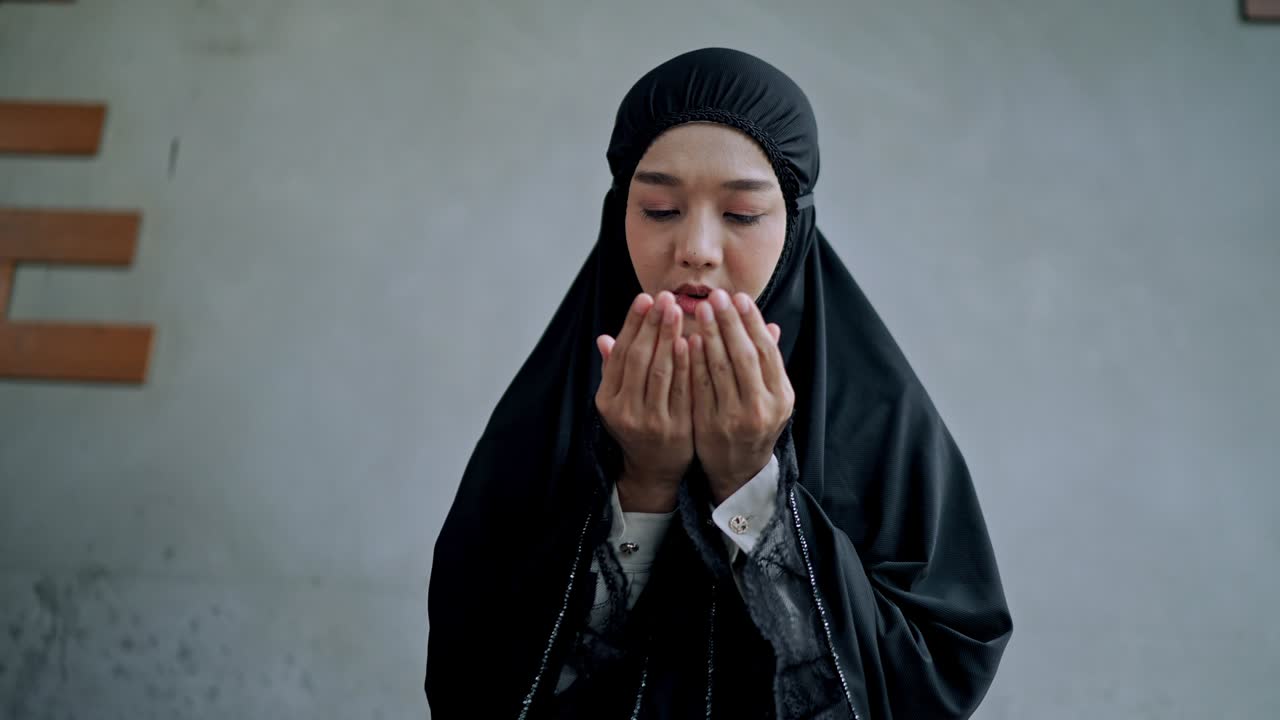 집에서 기도하는 아시아 젊은 무슬림 여성