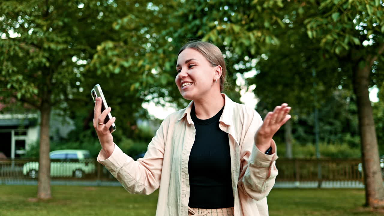 Mujer positiva hablando por teléfono mientras disfruta del verano en el parque. Mujer casual hablando por smartphone con un fondo natural, disfrutando del día soleado.