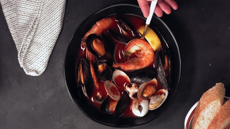 OVERHEAD FLAT LAY Seasonings falling into a bowl with seafood soup. 420 FPS slow motion shot with high speed camera